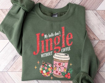May include: A dark green sweatshirt with the text "My bells don't Jingle without coffee" in red. The design includes a coffee cup, Christmas ornament, and holly. The sweatshirt has long sleeves with cuffed wrists.