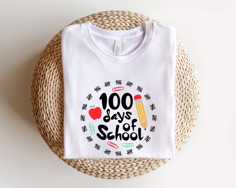 May include: White t-shirt with a black and red graphic that says "100 days of school" surrounded by black hash marks and colorful paper clips.