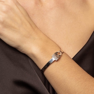 Könnte beinhalten: Silberarmband mit einem Vorhängeschloss-Anhänger, auf dem "LOVE" und ein Unendlichkeitszeichen stehen.