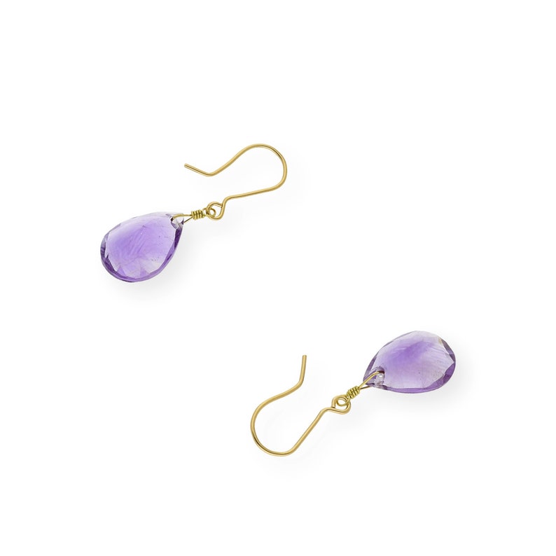 May include: A pair of gold earrings with purple amethyst teardrop-shaped stones.