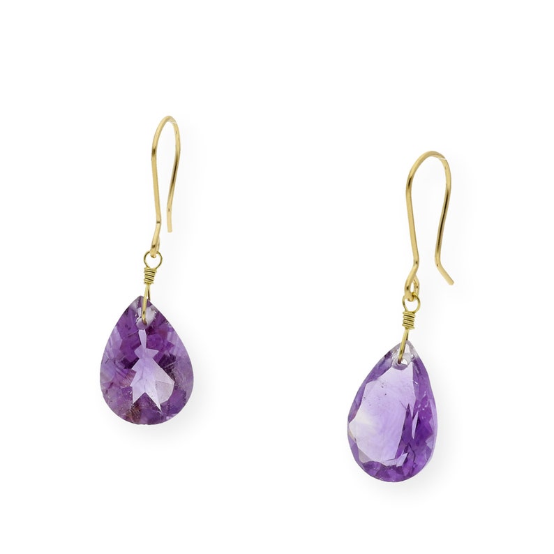 May include: A pair of gold earrings with purple amethyst teardrop-shaped stones.