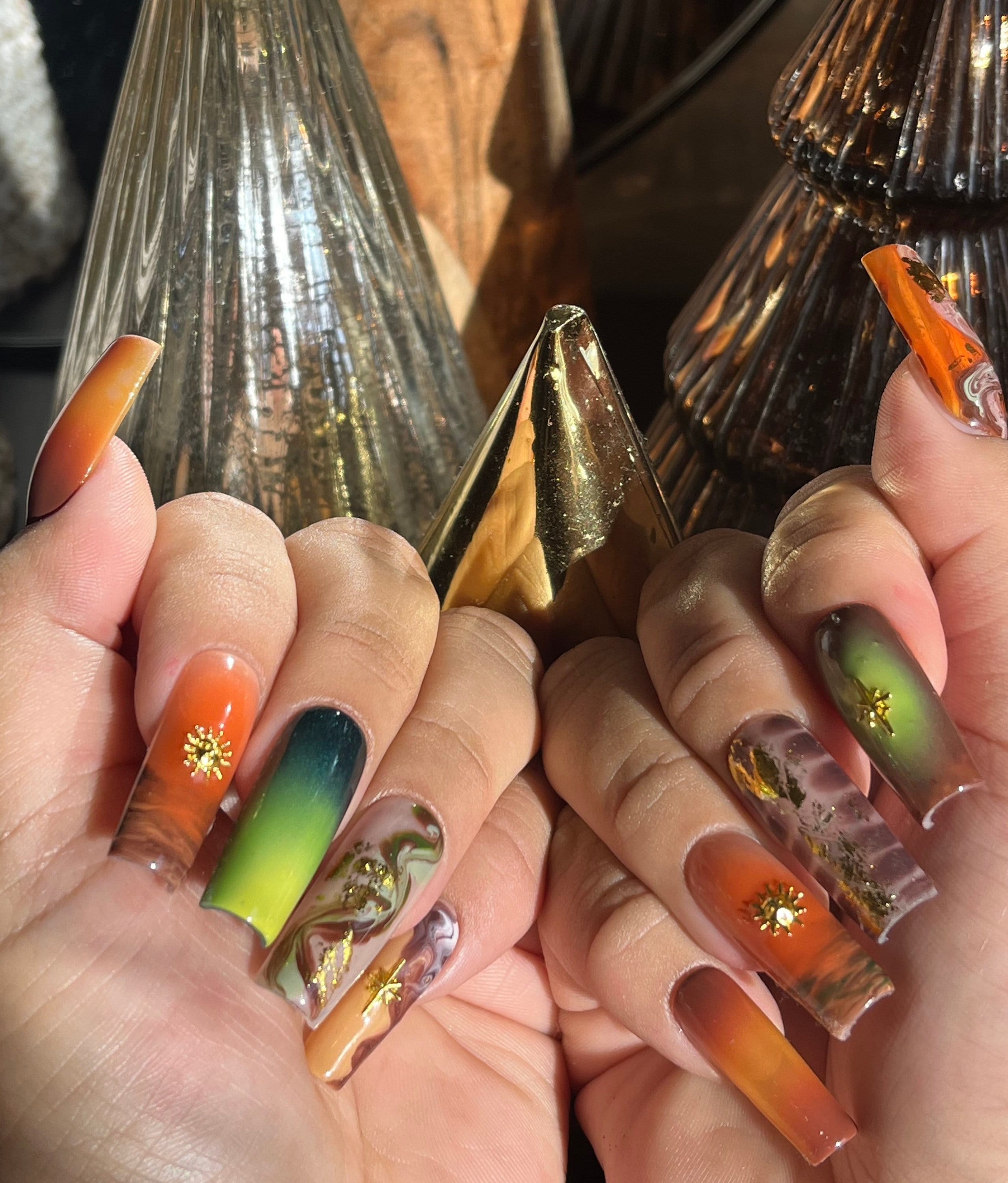 Earthling |Mixed green amber rust brown abstract swirl, airbrush w/ gold star and sun charms | Apres Gel X| Fall press ons | Long Square