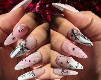 Cyber coquette| |  Milky white + pink airbrush base w/ silver chrome bow accents, star + heart charms Apres gel x | Long Almond