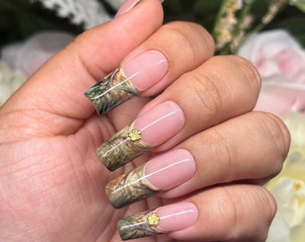 Camo fleur | Green, tan, brown real tree camo French tips with tiny gold flower rivet accents | Spring Summer | Long Square | Apres Gel X