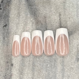 May include: Five white and nude fake nails with a white french tip and a thin white line design.