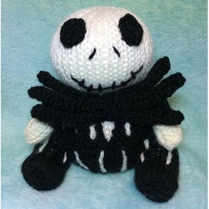 May include: A crocheted plush toy of Jack Skellington from the Nightmare Before Christmas. The toy is white with black details and has a black bow tie.