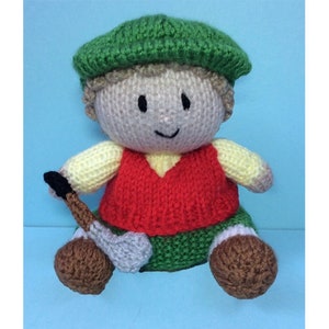 Könnte beinhalten: Eine gestrickte Puppe mit grünem Hut, roter Weste und grüner Hose. Die Puppe hält einen Golfschläger.