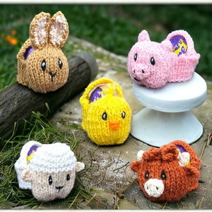 May include: Five knitted Easter egg holders, each shaped like a different animal: a bunny, a chick, a pig, a lamb, and a cow. The holders are all made with colourful yarn and have a cute, whimsical look.