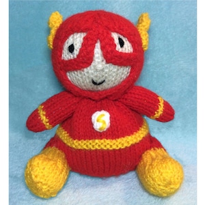 May include: A knitted plush toy of the Flash superhero. The toy is red with yellow accents and a lightning bolt symbol on the chest. The toy has a white face with black eyes and a smiling mouth.