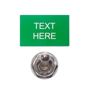 May include: A green rectangular sign with the text "TEXT HERE" in white lettering, and a silver toggle switch.