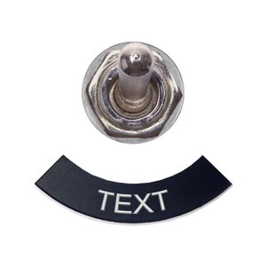 May include: A silver toggle switch with a black toggle plate that says "TEXT" in white lettering.