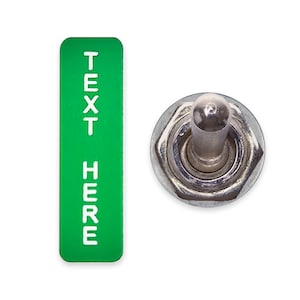 Puede incluir: Una etiqueta rectangular verde con el texto "TEXT HERE" en letras blancas, junto a un interruptor de palanca plateado.