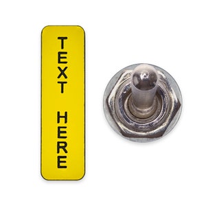 May include: A yellow rectangular label with the text "TEXT HERE" on it, next to a silver toggle switch.
