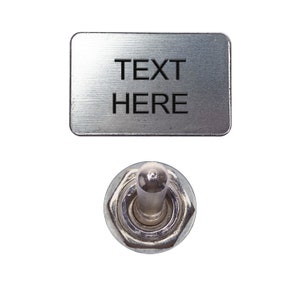 May include: A silver toggle switch with a metal plate that says "TEXT HERE" above it.
