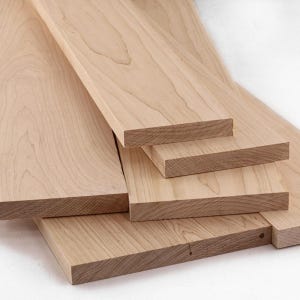 May include: Several unfinished wooden planks of varying sizes are arranged in a layered composition. The planks have a light brown color with visible wood grain, suggesting they are made of natural wood. The edges are clean-cut, and the overall appearance is smooth.