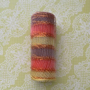 Pu&ograve; includere: Un rotolo di nastro in rete decorativa con strisce alternate di rosa, oro e beige. La rete &egrave; metallica e ha una finitura scintillante.