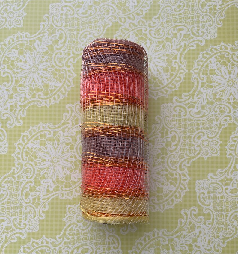 Pu&ograve; includere: Un rotolo di nastro in rete decorativa con strisce alternate di rosa, oro e beige. La rete &egrave; metallica e ha una finitura scintillante.
