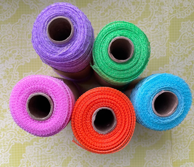 Pu&ograve; includere: Cinque bobine di nastro a rete di diversi colori. Le bobine sono viola, verde, rosa, arancio e blu.