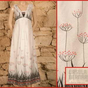 Puede incluir: Vestido blanco maxi con escote en V y estampado floral. El vestido tiene un corpiño ajustado y una falda fluida. La tela es ligera y tiene un brillo sutil. El vestido está hecho por Ursula Bernard London y está hecho en Inglaterra.