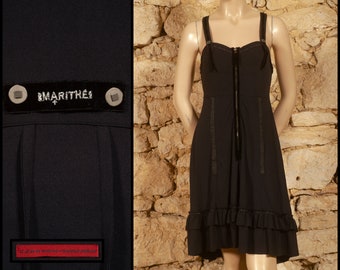 Könnte beinhalten: Ein schwarzes Kleid mit einem Rüschen-Saum und einem Reißverschluss vorne. Das Kleid hat ein Etikett mit der Aufschrift "MARITHÉ + FRANÇOIS GIRBAUD".