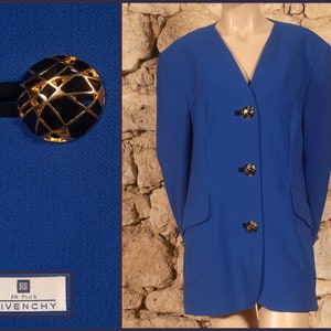 May include: A royal blue blazer with a v-neck and three gold buttons. The blazer has two pockets and the label "EN PLUS GIVENCHY" is visible on the bottom left.