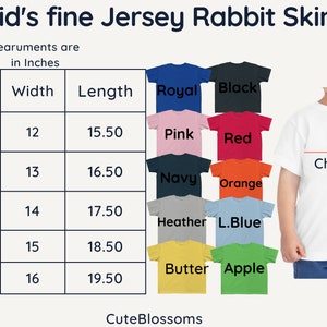 May include: Size chart for kids' fine jersey rabbit skin t-shirts. The chart shows sizes 2T through 7T with corresponding width and length measurements in inches. The chart also shows a variety of colors for the t-shirts, including royal, black, pink, red, navy, orange, heather, light blue, butter, and apple.