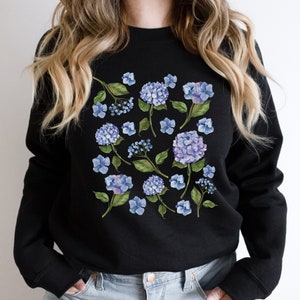 BEAUTIFUL BLUE HYDRANGEA FLOWERS GRAPHIC DESIGN PRINTED ON A HEAVY BLEND WOMENS SWEATSHIRT.