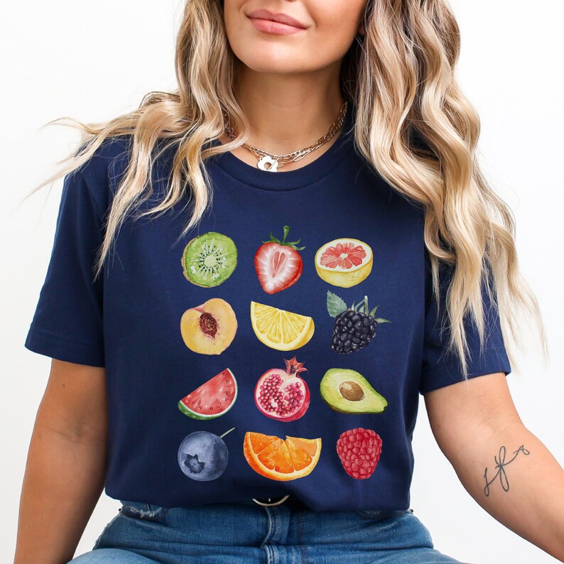 May include: A navy blue t-shirt with a colorful fruit print. The print features a variety of fruits, including kiwi, strawberry, grapefruit, peach, lemon, blackberry, watermelon, pomegranate, avocado, blueberry, orange, and raspberry.