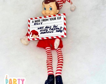 May include: A red and white striped elf doll holding a note that says "A note from your elf Billy well done for using excellent manners today!"