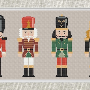 Può includere: Quattro figurine di schiaccianoci giocattolo con diversi design. La prima è un soldato rosso e nero con un cappello nero alto. La seconda è un soldato rosso e verde con un cappello rosso alto. La terza è un soldato verde e rosso con un cappello nero alto. La quarta è un soldato nero e verde con una corona dorata.