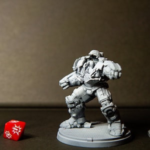 Może przedstawiać: Szara, szczegółowa miniatura robota w pozie bojowej, stojącego na szarej podstawie. Robot ma duży, szary hełm i szarą osłonę klatki piersiowej. Robot trzyma szarą broń w prawej ręce. Po lewej stronie obrazu znajduje się szara lampa uliczna, a po prawej stronie obrazu znajduje się szare światło drogowe. Czerwona dwudziestościenna kostka znajduje się w środku obrazu.