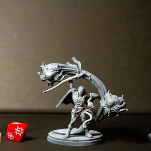 Peut inclure: Une figurine miniature peinte en gris d'une personne tenant un bâton avec deux figurines miniatures peintes en gris de créatures de chaque côté du bâton. La figurine est debout sur une base peinte en gris. Il y a un lampadaire miniature peint en gris à gauche et un feu de circulation miniature peint en gris à droite.
