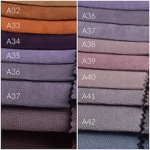 Peut inclure: Gros plan sur des &eacute;chantillons de tissu de diff&eacute;rentes couleurs, allant des bruns et oranges aux violets et gris. Chaque &eacute;chantillon est &eacute;tiquet&eacute; avec un code, comme A32, A33 et A34. Le tissu semble &ecirc;tre une mati&egrave;re textur&eacute;e, peut-&ecirc;tre pour la tapisserie ou la d&eacute;coration int&eacute;rieure.