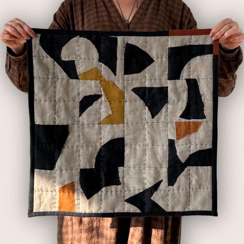 Holding an abstract found shapes applique patchwork