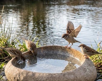 Handcrafted river stone birdbaths available in various sizes.
