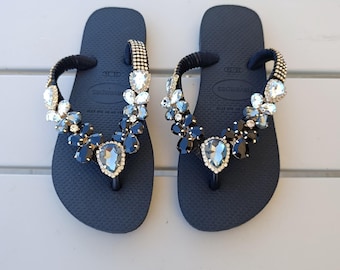 Black and customized Havaianas, decorated with various crystals. Women's beachwear.