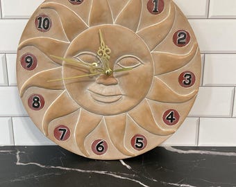 Reloj de cerámica con diseño de sol celestial. 12,25 cm de diámetro.