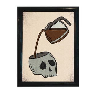 May include: Framed art print featuring a coffee pot pouring coffee into a skull. The coffee pot is brown and gray, and the skull is gray with black shading. The background is off-white, and the frame is black.