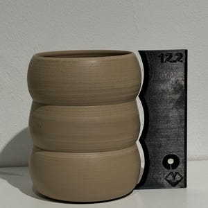 Könnte beinhalten: Ein hellbrauner Keramiktopf mit drei übereinander gestapelten Abschnitten. Der Topf ist 12,2 Zoll (31 cm) hoch.