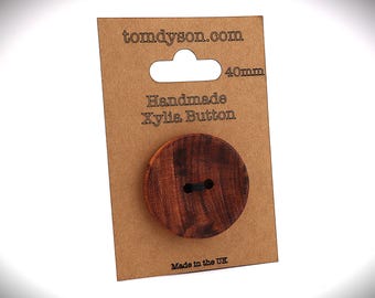 May include: A handmade Xylia button, 40mm in diameter, displayed on a brown card. The button is a rich, dark brown with visible wood grain. The card has the text "tomdyson.com" and "Handmade Xylia Button".