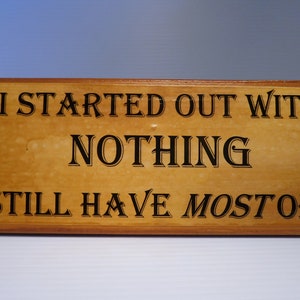 May include: A wooden sign with the text "I started out with nothing I still have most of it".