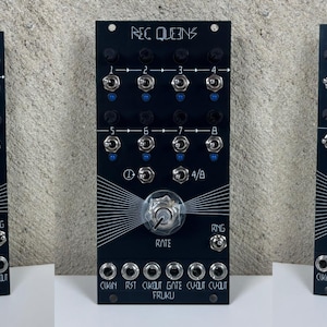 May include: Three black electronic circuit boards with silver knobs and blue accents. Each board has the text "REC QUEENS" at the top and various labeled ports. The boards have a central knob labeled "RATE" and "RNG" on the side.