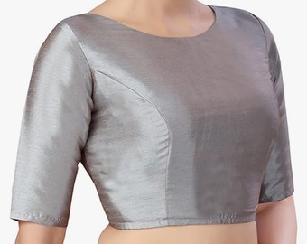 May include: A silver-gray blouse with a round neckline and elbow-length sleeves. The fabric has a subtle sheen, and the seams are neatly tailored. The blouse is a classic style, suitable for various occasions.