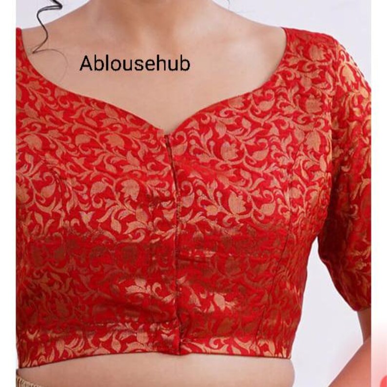 May include: Red brocade blouse with a gold floral pattern and a button-up front.
