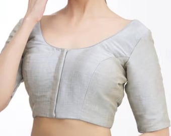 May include: A light gray blouse with elbow-length sleeves. The blouse has a scoop neckline and a tailored fit. The fabric appears to have a subtle sheen. The garment is a classic style, suitable for various occasions.