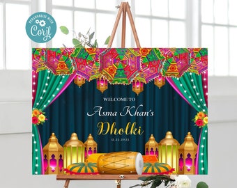 May include: A welcome sign for Asma Khan's Dholki on December 23, 2023. The sign features a colorful Indian-inspired design with lanterns, a drum, and a floral arrangement.