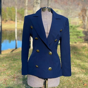 May include: A navy blue blazer with gold buttons. The blazer has a double-breasted closure and a fitted silhouette.