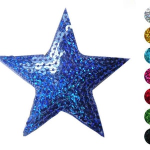 Könnte beinhalten: Ein blauer sternförmiger Pailletten-Patch. Der Patch besteht aus kleinen, schimmernden Pailletten, die einen schimmernden Effekt erzeugen. Der Stern hat einen Durchmesser von etwa 7,5 cm.