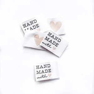 May include: Four white fabric labels with black text and pink hearts. The labels read "HAND MADE with" and "HAND MADE".