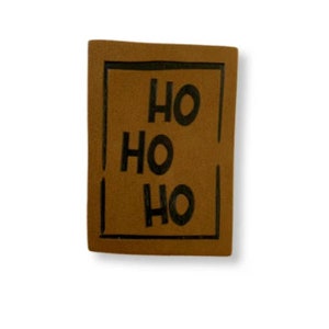 May include: A brown leather patch with a black border and the text "HO HO HO" inside.
